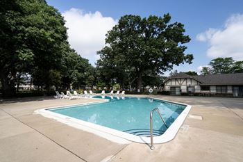 a swimming pool with chaise lounge chairs and trees in the background at Beacon Hill and Great Oaks Apartments, Illinois, 61109